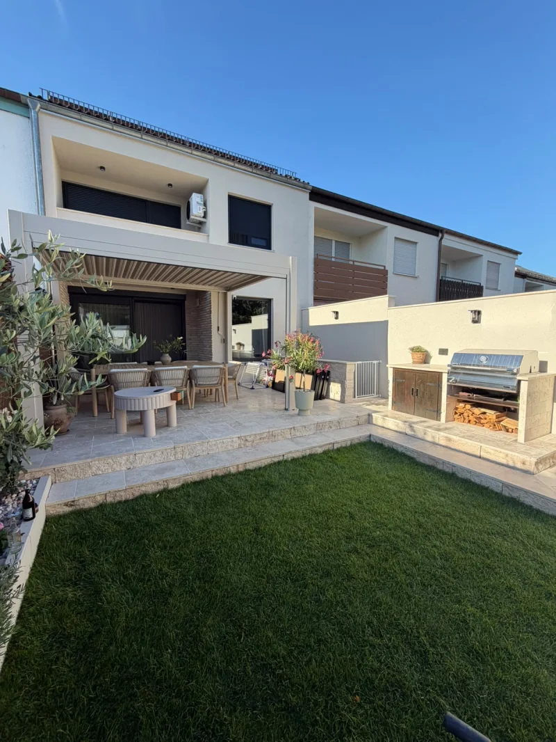 Gartenterrasse aus Travertin mit Olivenbaum und Grillbereich